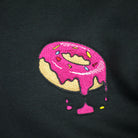 A close up of an embroidered donut on a black sweatshirt