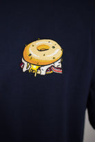 Close up of embroidered Bagel design on a navy T-Shirt by The Embroidery Crew