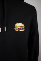 Close up of embroidered burger design on a black Hoodie by The Embroidery Crew