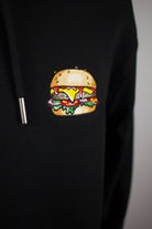 Close up of embroidered burger design on a black Hoodie by The Embroidery Crew