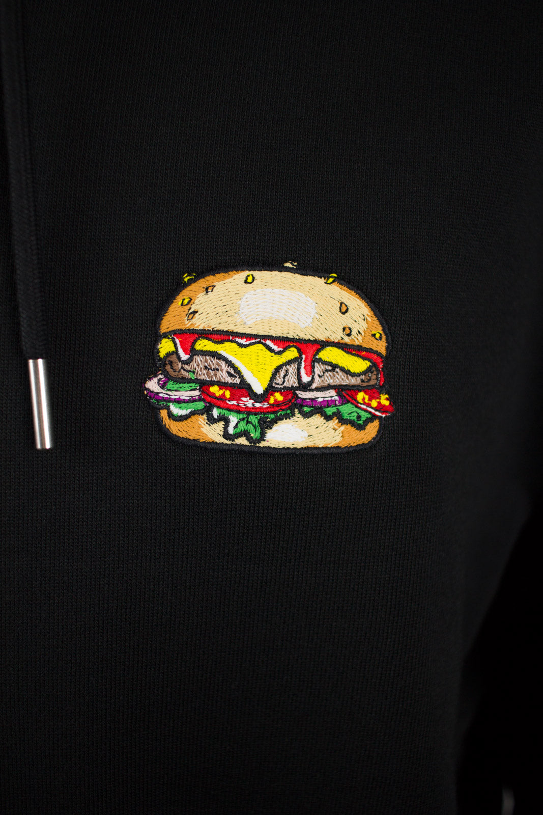Close up of embroidered burger design on a black Hoodie by The Embroidery Crew