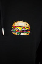 Close up of embroidered burger design on a black Hoodie by The Embroidery Crew