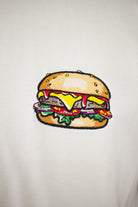 Close up of embroidered Burger design on a white T-Shirt by The Embroidery Crew
