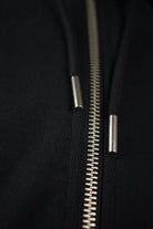 Close up of a Zipper and Drawstrings from black Zip Up Hoodie by The Embroidery Crew