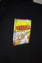 Close up of embroidered cereals design on a black Zip Up Hoodie by The Embroidery Crew