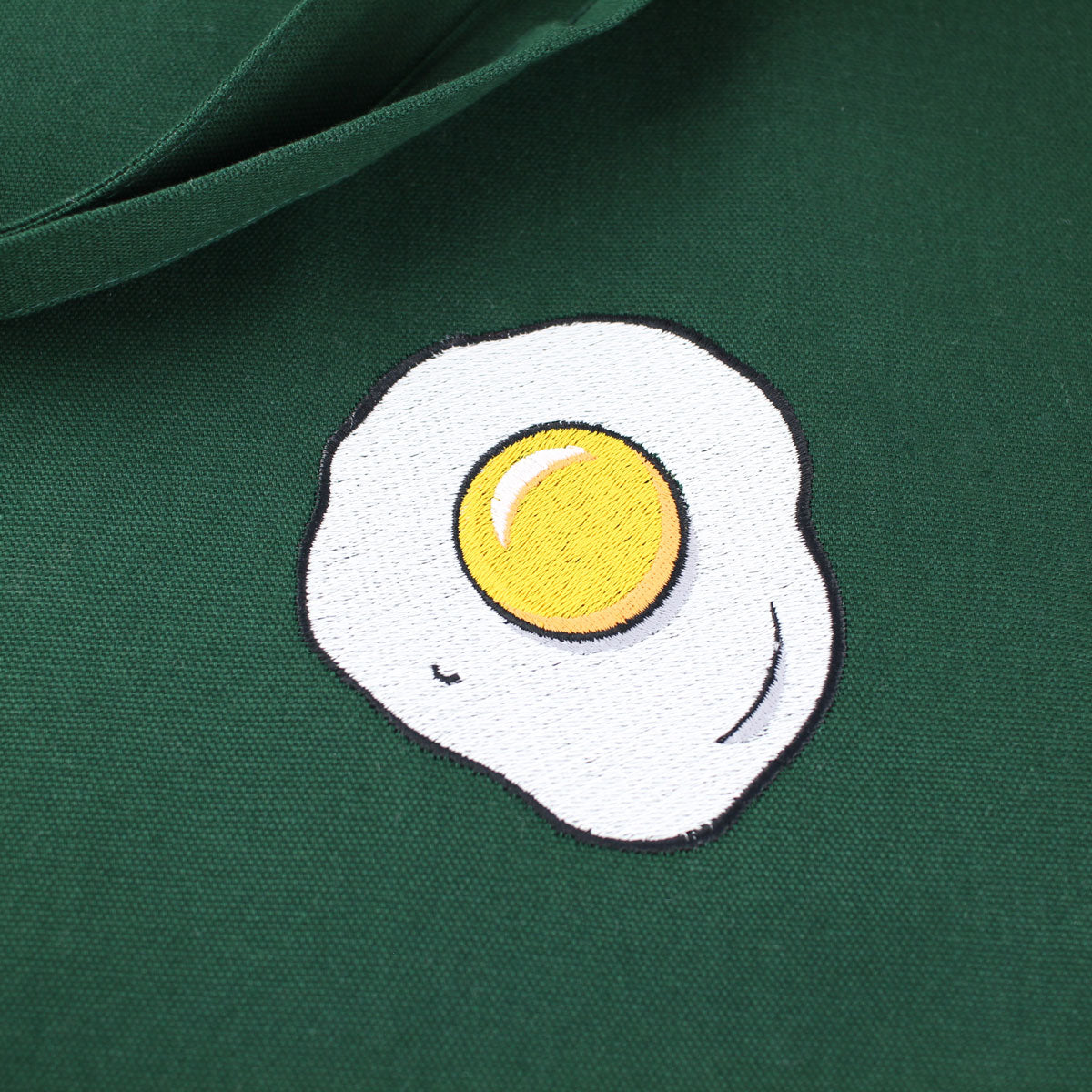 Close up of a green tote bag with Egg embroidery by The Embroidery Crew