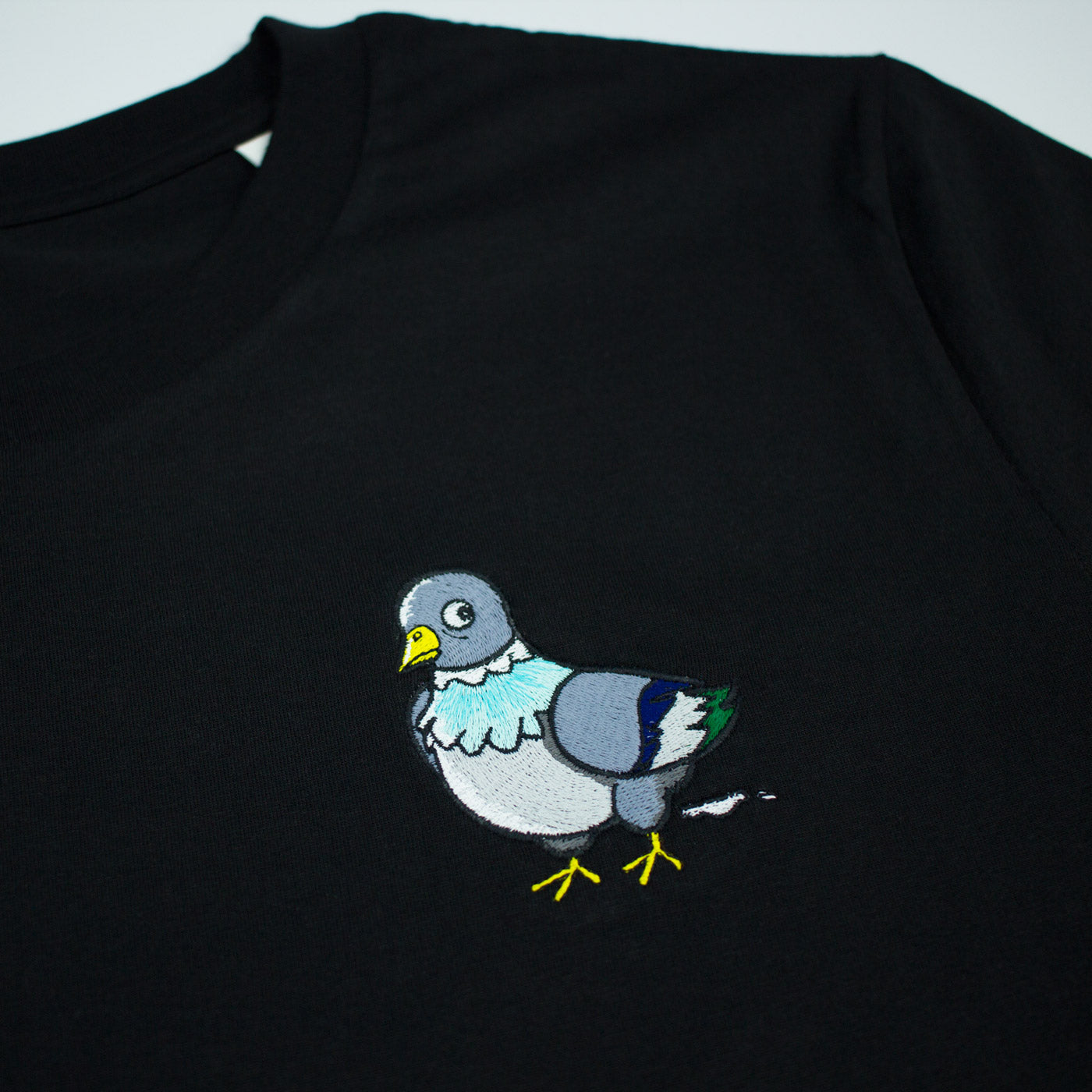 Black T-shirt with pigeon embroidery close up