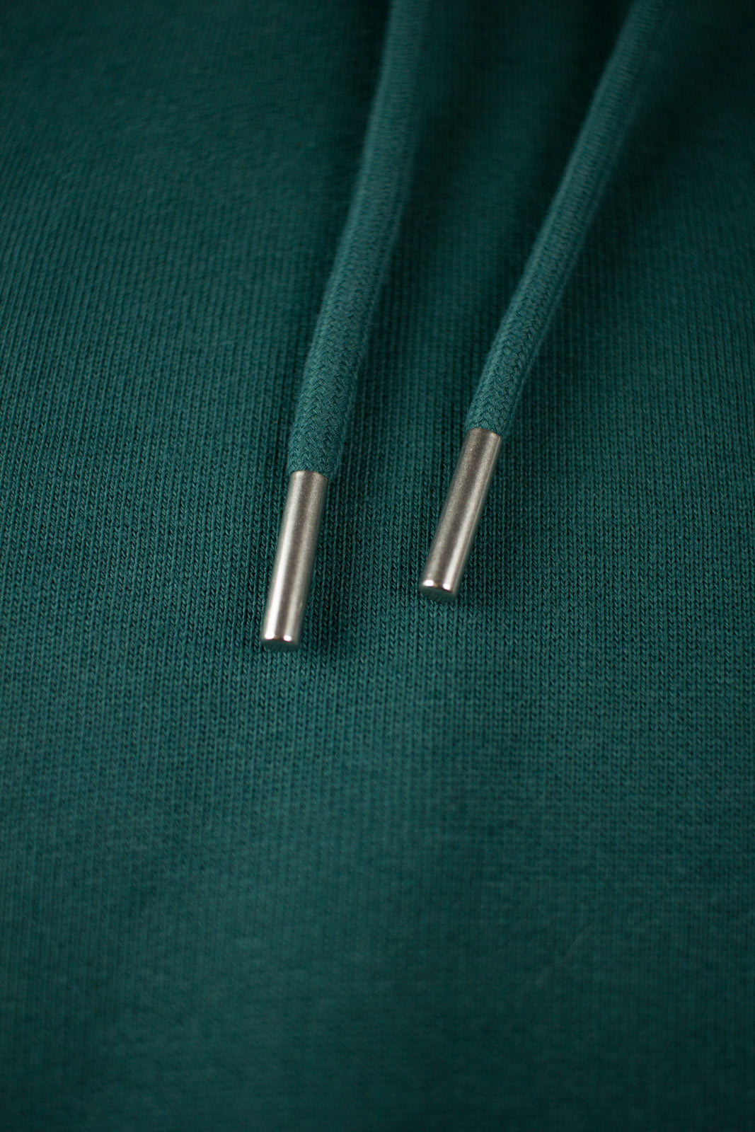 Close up of drawstrings from a green Hoodie by The Embroidery Crew
